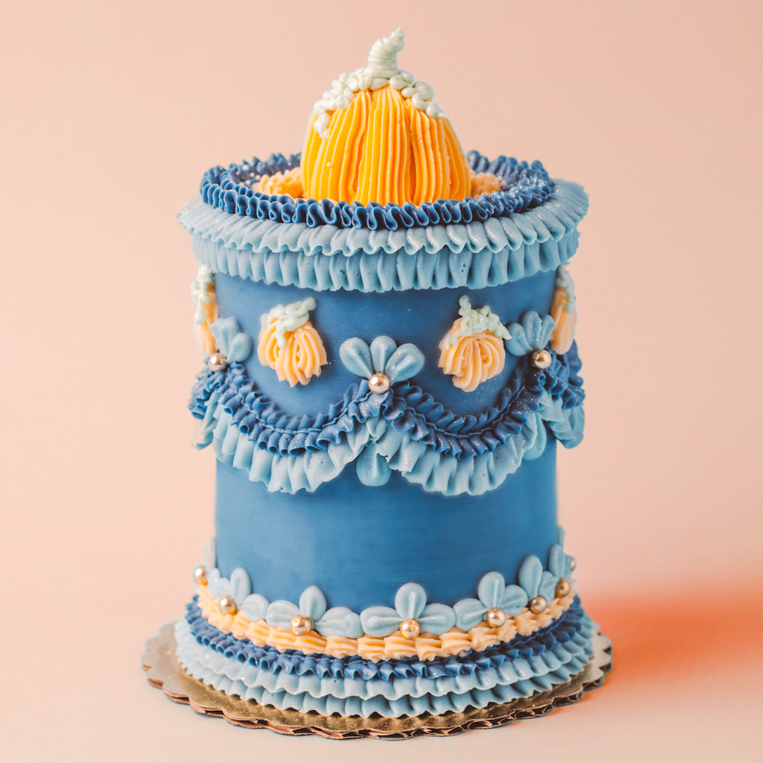 Decorative blue cake with floral details on a beige background