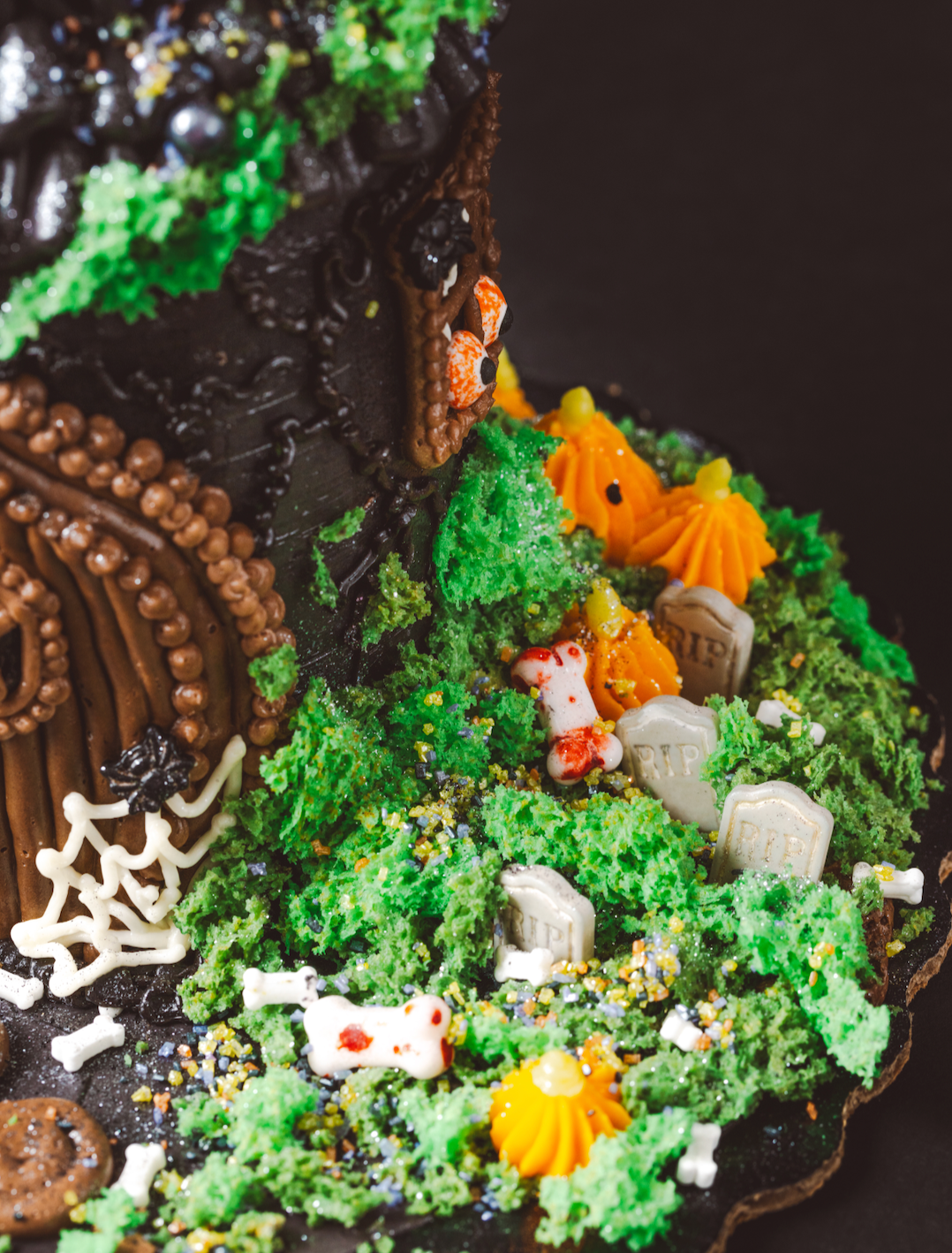 Halloween-themed cookie house with decorative elements on a dark background