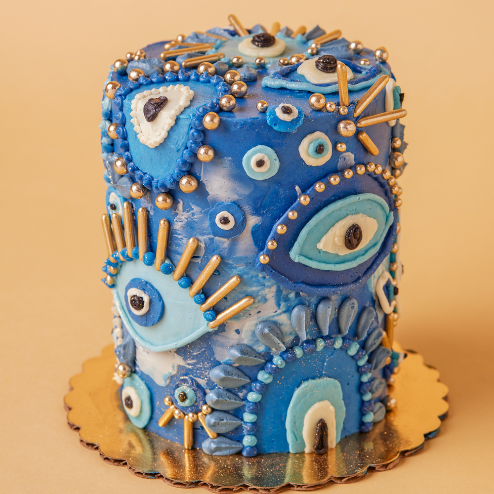 Decorative cake with blue and gold icing on a beige background