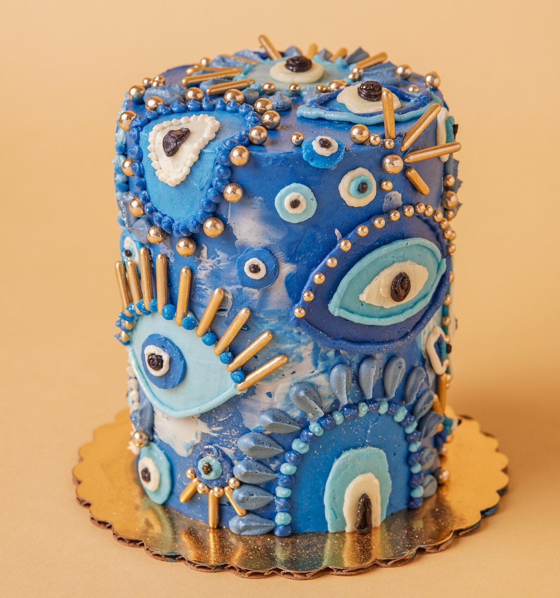 Decorative cake with blue and gold icing on a beige background