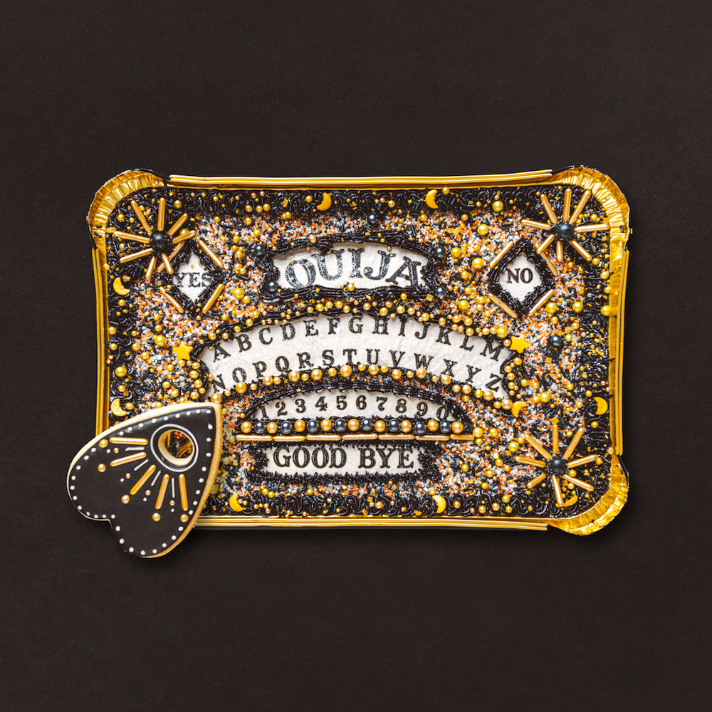 Decorative keychain with ouija board design on a black background