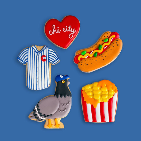 Set of colorful pins including a heart, hot dog, corn on the cob, and pigeon on a blue background